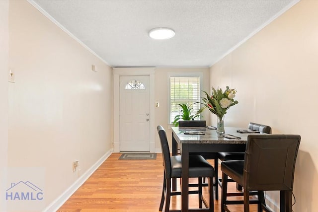 1514 Augusta Ave, Savannah, GA 31415 - dining area with light wood-style flooring, crown molding, baseboards, and a textured ceiling