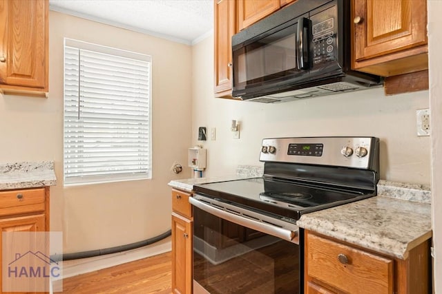 1514 Augusta Ave, Savannah, GA 31415 - kitchen with crown molding, black microwave, electric range, a textured ceiling, and light wood-type flooring