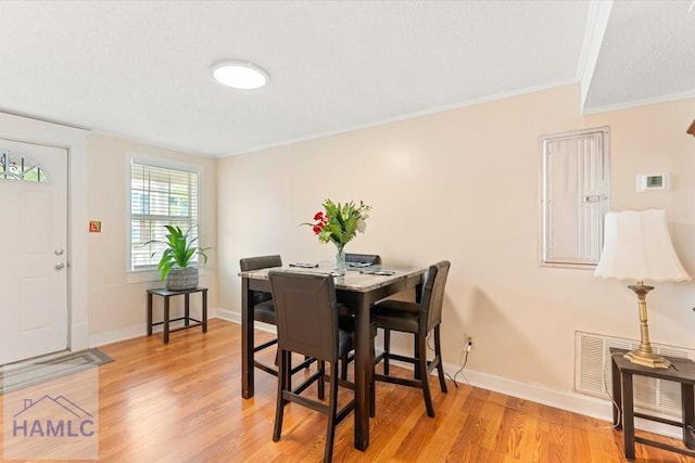 1514 Augusta Ave, Savannah, GA 31415 - dining area featuring light wood-style floors, baseboards, crown molding, and visible vents