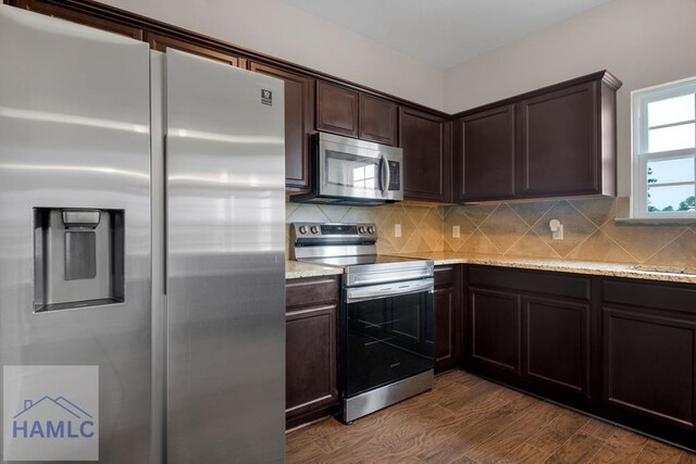 247 Morgan Field Blvd, Ludowici, GA 31316 - kitchen featuring stainless steel appliances, dark brown cabinets, decorative backsplash, dark wood finished floors, and light stone countertops