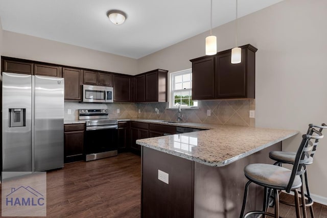 247 Morgan Field Blvd, Ludowici, GA 31316 - kitchen featuring stainless steel appliances, a sink, dark brown cabinetry, a peninsula, and dark wood-style flooring