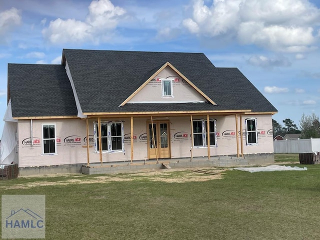 property in mid-construction with a porch, a shingled roof, and a front lawn