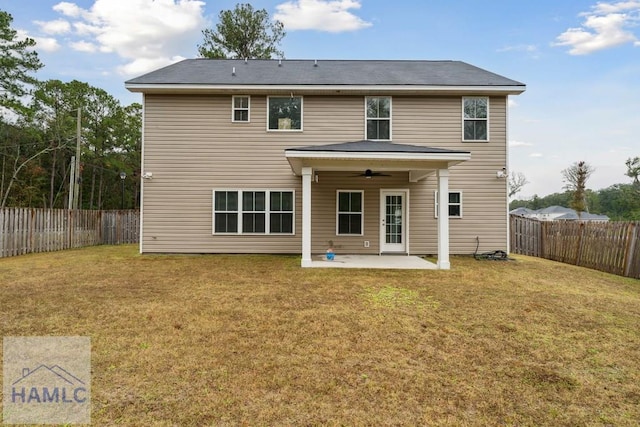 rear view of property with ceiling fan, a yard, and a patio