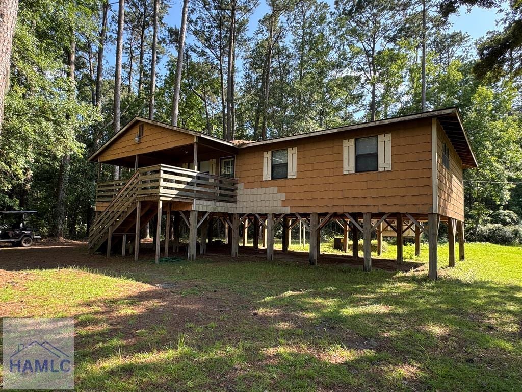 228 Circle Rd, Midway, GA 31320 - view of front facade featuring a front lawn, stairway, and a deck