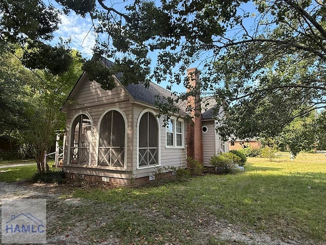 147 S Elm St, Jesup, GA 31545 - view of home's exterior featuring roof with shingles, a lawn, crawl space, and a chimney