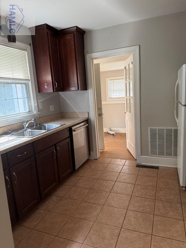 147 S Elm St, Jesup, GA 31545 - kitchen featuring freestanding refrigerator, stainless steel dishwasher, light countertops, and light tile patterned floors