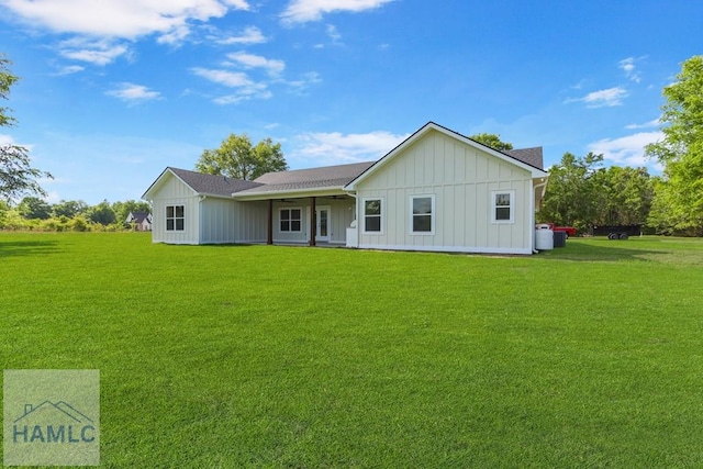 back of house featuring board and batten siding, a lawn, and ceiling fan