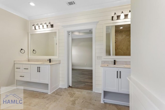 bathroom featuring two vanities, a sink, and visible vents