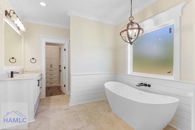 full bath featuring crown molding, vanity, a freestanding tub, an inviting chandelier, and recessed lighting