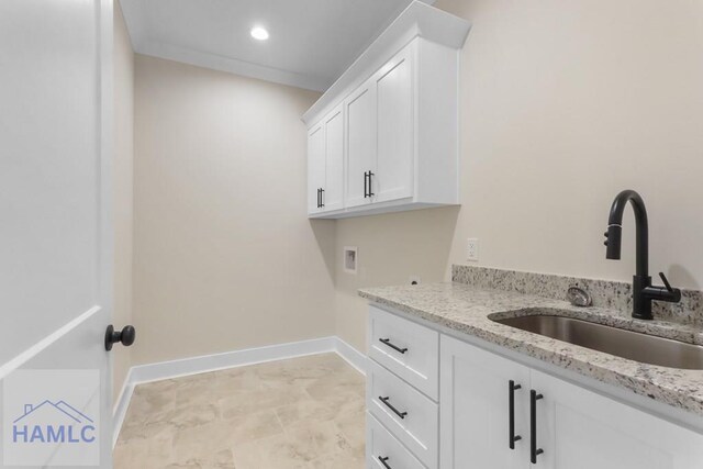 laundry area featuring a sink, baseboards, hookup for a washing machine, marble finish floor, and cabinet space