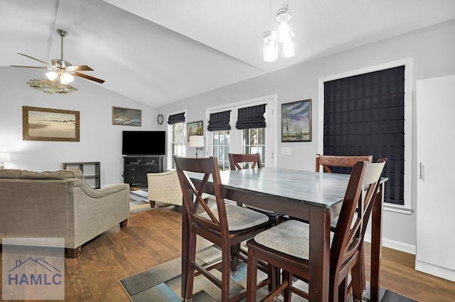 dining room with dark hardwood / wood-style floors, vaulted ceiling, and ceiling fan