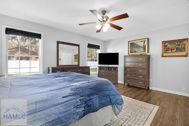 bedroom with multiple windows, ceiling fan, and dark hardwood / wood-style floors