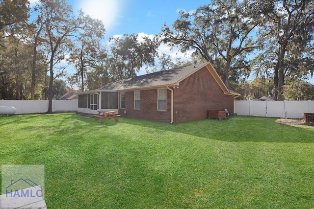 back of house with a lawn and a sunroom