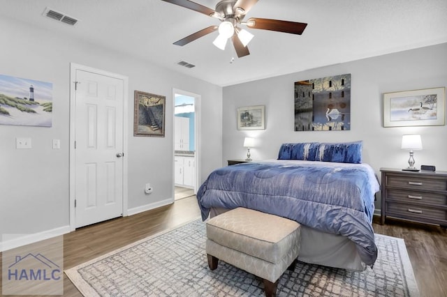 bedroom with ensuite bath, ceiling fan, and dark wood-type flooring