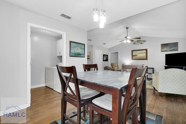 dining room with washer and clothes dryer, ceiling fan, dark hardwood / wood-style flooring, and vaulted ceiling