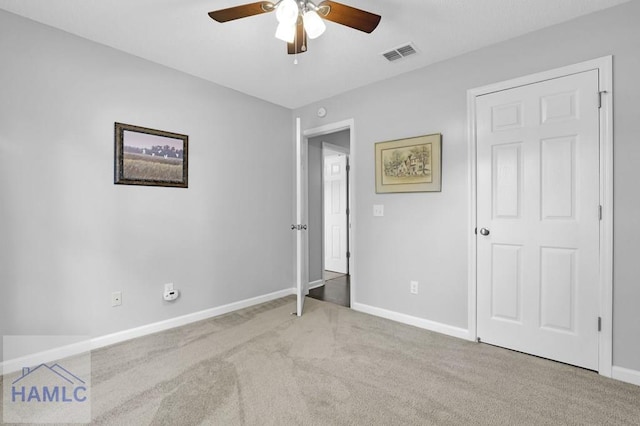 unfurnished bedroom with ceiling fan and light colored carpet