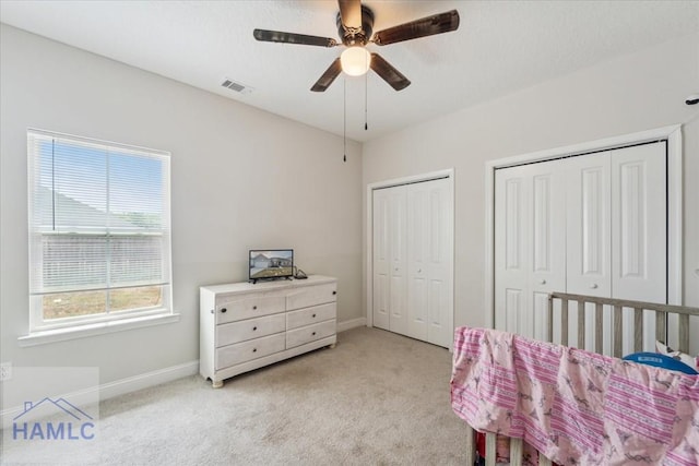 91 Thomas Way SE, Ludowici, GA 31316 - bedroom featuring light colored carpet, two closets, and ceiling fan