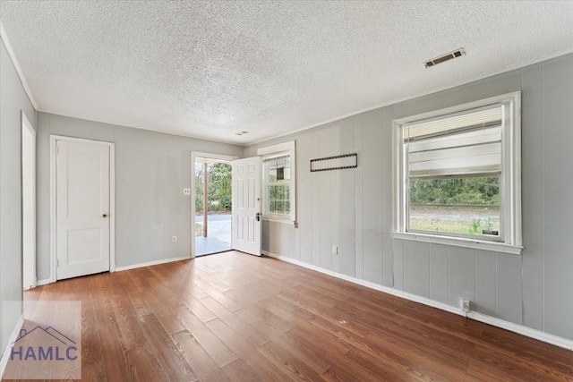 spare room featuring hardwood / wood-style floors and a healthy amount of sunlight