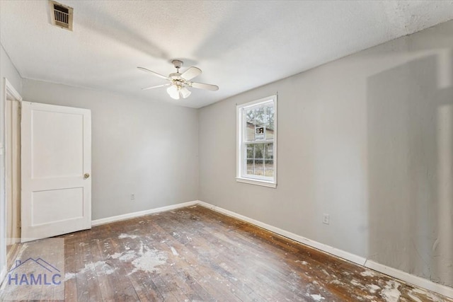 empty room featuring ceiling fan, a textured ceiling, and dark hardwood / wood-style flooring