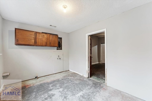 unfurnished room with a textured ceiling