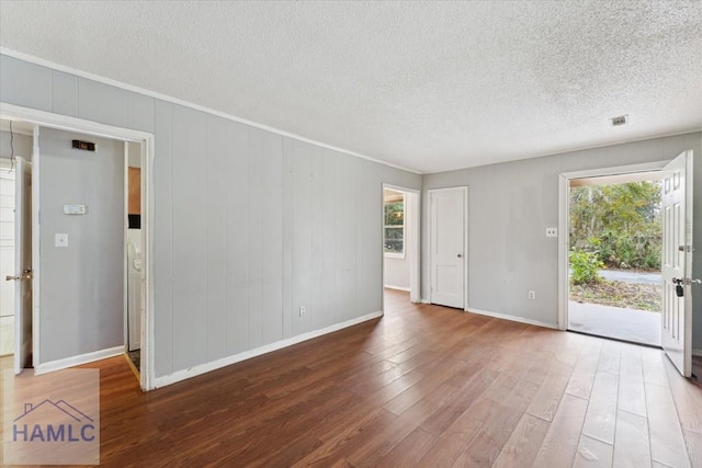 spare room featuring dark wood-type flooring and a textured ceiling