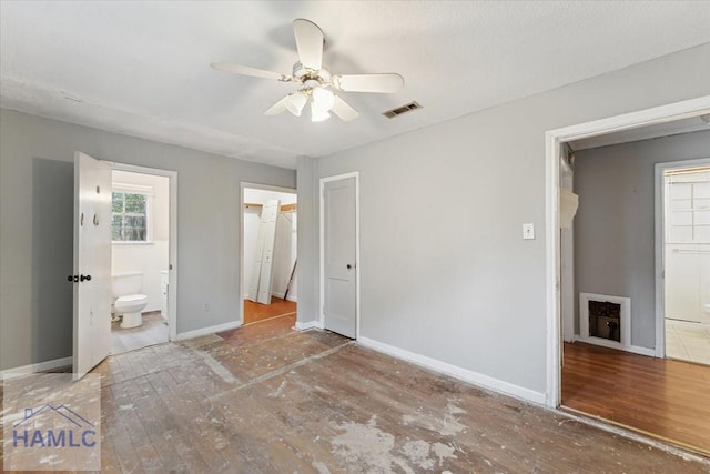 unfurnished bedroom featuring a closet, ceiling fan, and connected bathroom