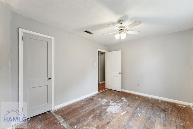 unfurnished bedroom featuring ceiling fan, dark hardwood / wood-style floors, and a textured ceiling