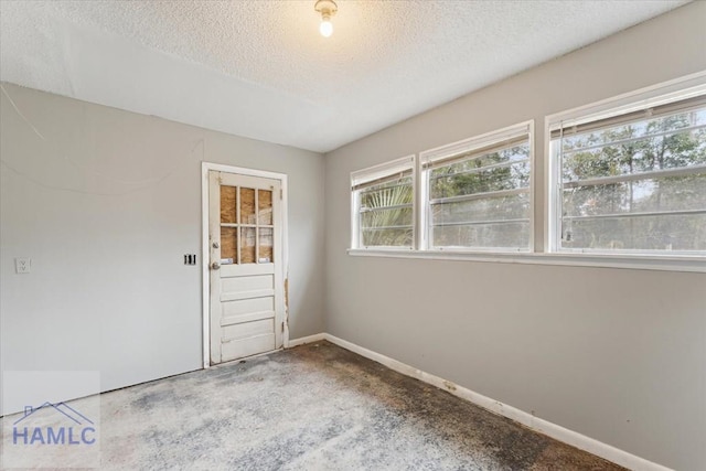 unfurnished room with a textured ceiling