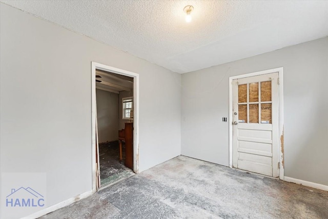 unfurnished room with concrete floors and a textured ceiling