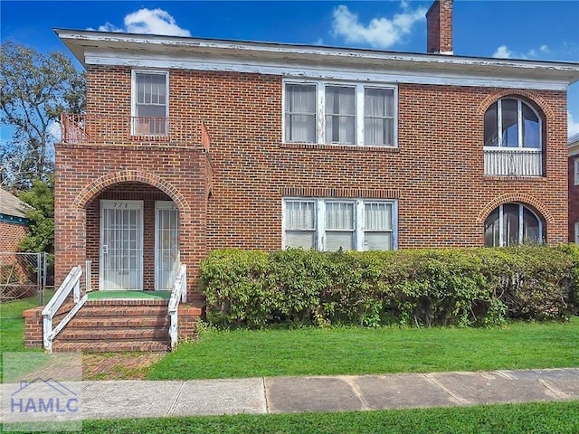 view of front of house with brick siding and a front lawn