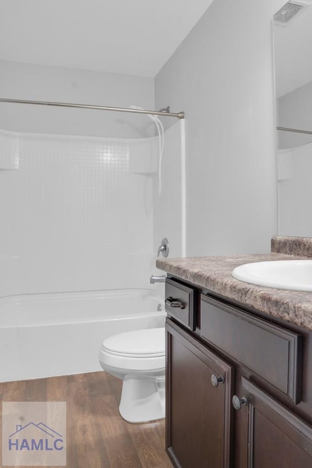 full bathroom with wood-type flooring, vanity, toilet, and shower / washtub combination