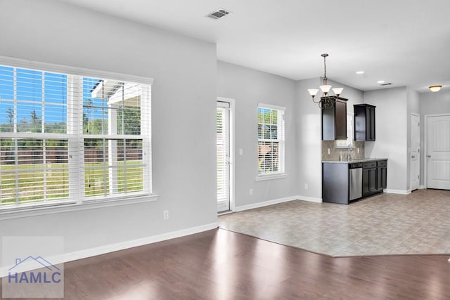 kitchen with dark hardwood / wood-style flooring, an inviting chandelier, a wealth of natural light, and sink