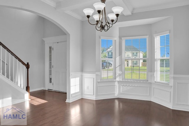 foyer entrance featuring beamed ceiling, crown molding, dark wood-type flooring, and an inviting chandelier