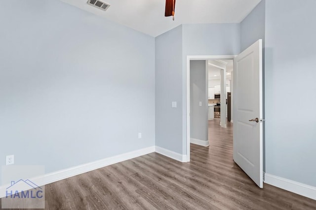 unfurnished bedroom with ceiling fan, wood finished floors, visible vents, and baseboards