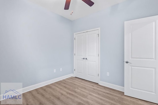 unfurnished bedroom featuring a closet, ceiling fan, baseboards, and wood finished floors