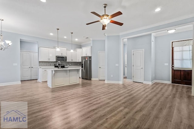 kitchen featuring a sink, decorative backsplash, open floor plan, and stainless steel appliances