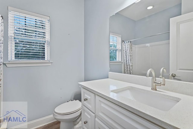 bathroom with toilet, wood finished floors, a shower with shower curtain, baseboards, and vanity