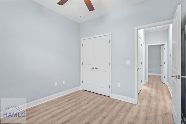 unfurnished bedroom featuring light wood finished floors, a closet, baseboards, and a ceiling fan