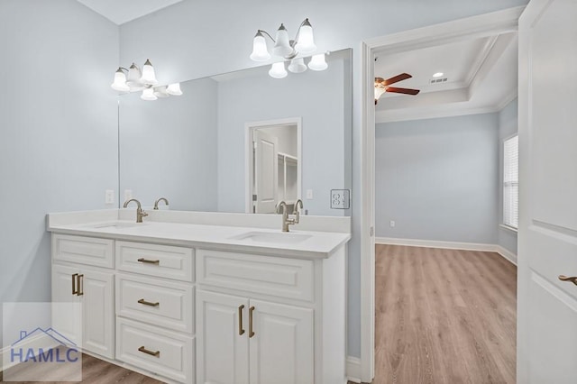 full bath featuring a sink, double vanity, wood finished floors, and crown molding