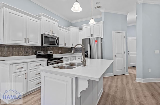 kitchen featuring visible vents, crown molding, light countertops, stainless steel appliances, and a sink