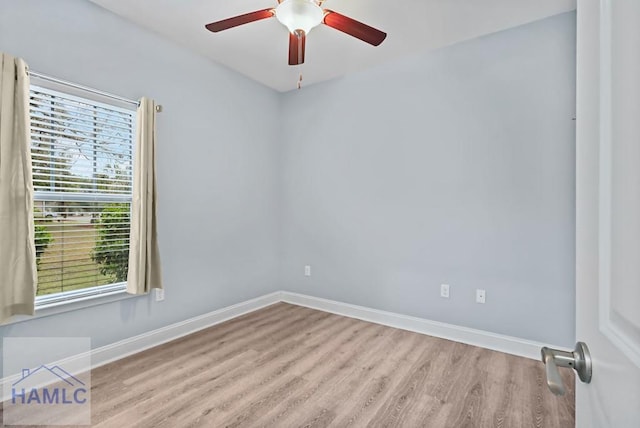 empty room with a ceiling fan, baseboards, and wood finished floors