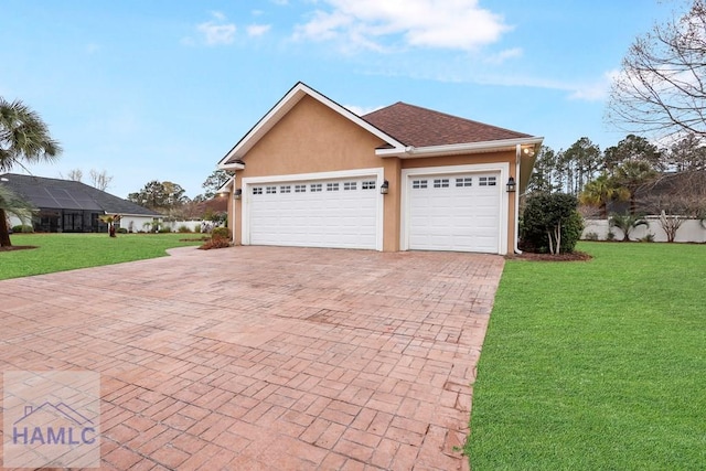 view of front of property with stucco siding, decorative driveway, a garage, and a front lawn