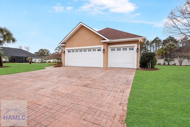 view of front of property with decorative driveway, a garage, a front yard, and stucco siding