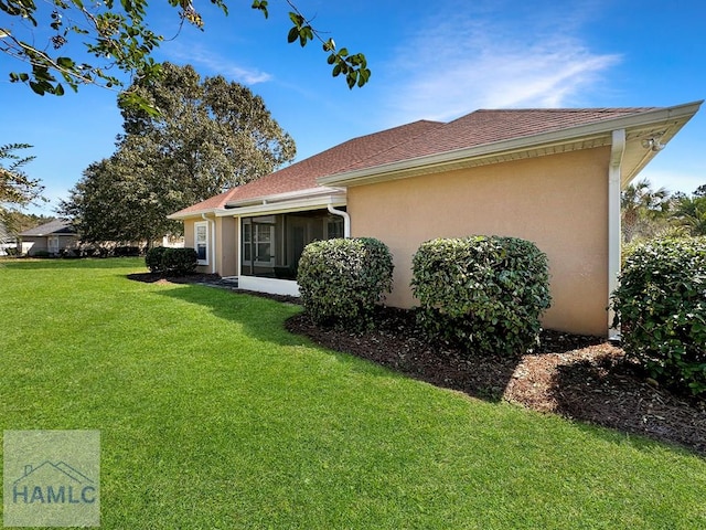 view of side of home with a yard and stucco siding