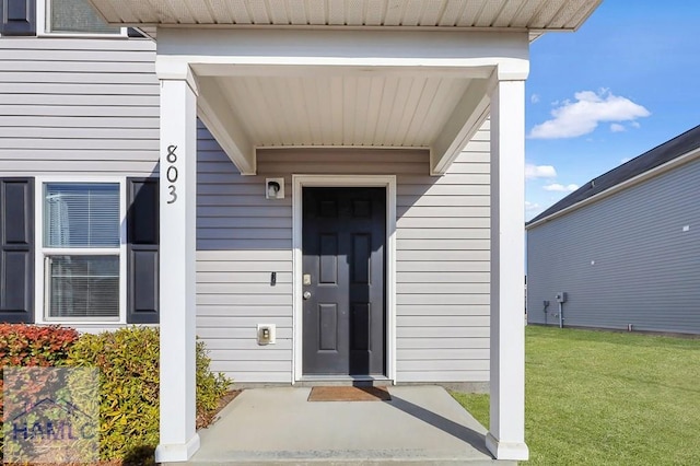 doorway to property featuring a lawn