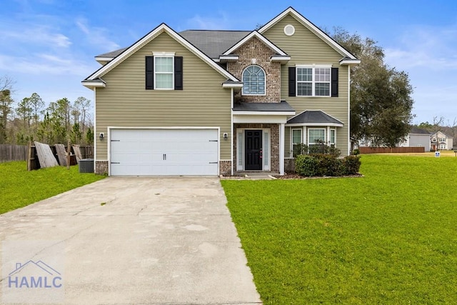 view of front facade with brick siding, fence, a front yard, a garage, and driveway