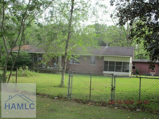 view of front of house with brick siding, fence, and a front yard