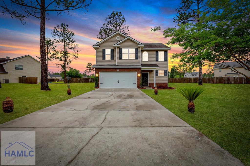 399 Murray Crossing Blvd NE, Ludowici, GA 31316 - view of front of home featuring fence, an attached garage, concrete driveway, and a front lawn