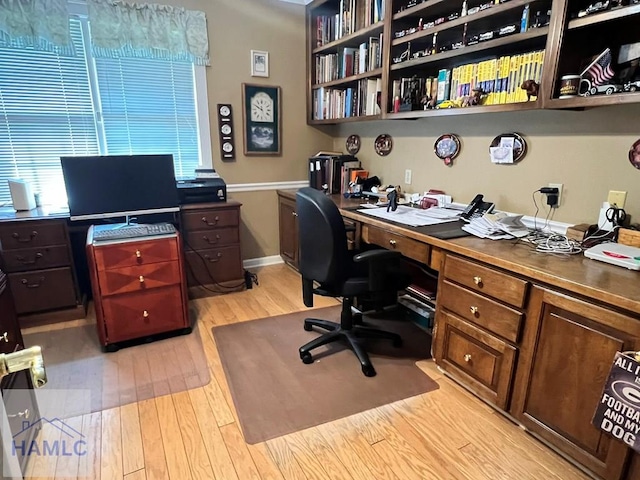 home office with light hardwood / wood-style floors