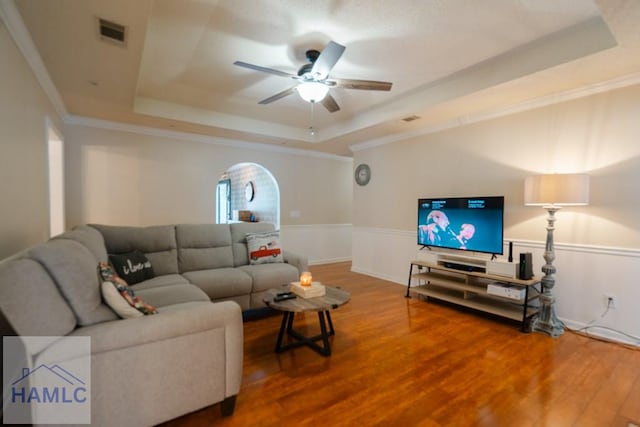 living room featuring visible vents, ceiling fan, wood finished floors, and a raised ceiling